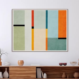 Peut inclure: Une œuvre d'art abstraite encadrée avec un design géométrique dans des tons de vert, orange, bleu et jaune est suspendue au-dessus d'une console multimédia en bois. La console a des pieds en métal noir et est remplie d'objets décoratifs. Une suspension sphérique en osier est suspendue au plafond.