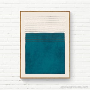 May include: Abstract art print with a teal blue rectangle and black horizontal lines. The print is framed in a light wood frame.