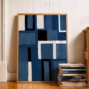May include: Abstract art print in a wooden frame with a blue, white, and black geometric pattern. The print is hanging on a white wall with a wooden bench in the foreground.