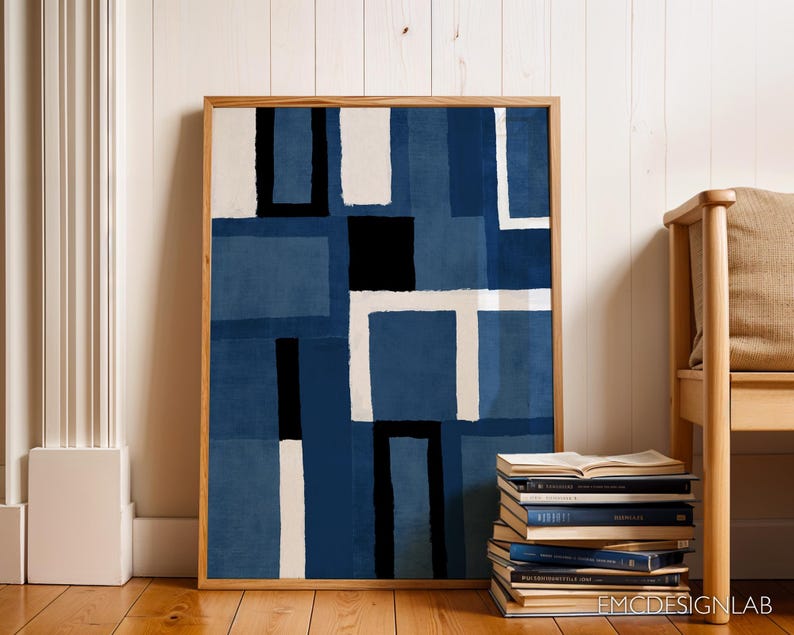 May include: Abstract art print in a wooden frame with a blue, white, and black geometric pattern. The print is hanging on a white wall with a wooden bench in the foreground.