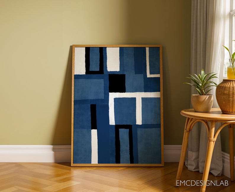 May include: Abstract art print with a geometric design in shades of blue and white. The print is framed in a natural wood frame.
