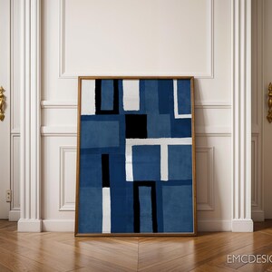 May include: Abstract geometric art print in shades of blue with white and black accents. The print is framed in a simple wooden frame.