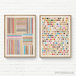 May include: Two framed abstract art prints with geometric patterns. The print on the left features a grid of colorful horizontal lines. The print on the right features a grid of colorful squares.
