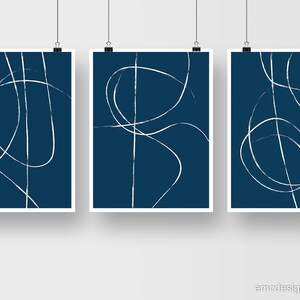 May include: Set of three abstract art prints with white lines on a dark blue background. The lines are simple and organic, creating a modern and minimalist look.
