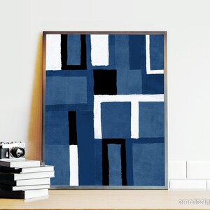 May include: Abstract geometric art print with a blue, white, and black color scheme. The print is framed in a dark wood frame.