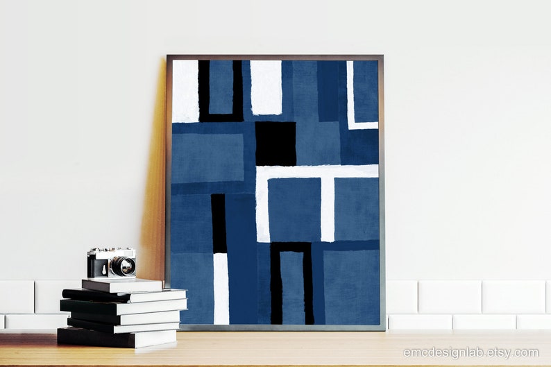 May include: Abstract geometric art print with a blue, white, and black color scheme. The print is framed in a dark wood frame.
