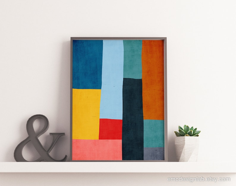 May include: Abstract geometric art print with a colorful design featuring shades of blue, red, yellow, orange, and green. The print is framed in a simple black frame.