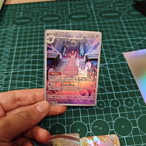May include: A Gengar Pokemon trading card featuring a purple ghost-like creature with red eyes, positioned at the top of a grand staircase within a gothic building. The card displays 130 HP, the Shadow Curse ability, and the Dark Mind attack text.