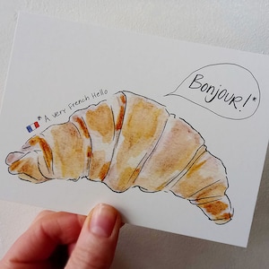 Tarjeta de felicitación con croissant Bonjour, postal de saludo, para decir hola, pastelería francesa, Francia, París, pan, saludo ilustrado, dibujado a mano, Cindy Mangomini