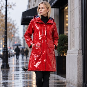 May include: A glossy, bright red raincoat featuring a hood, long sleeves, and two large front pockets with flaps. The coat has a button-down front closure and a dark interior lining. The logo EDGYESSENTIAL is printed in black near the bottom left.