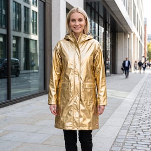 Könnte beinhalten: Ein goldfarbener Regenmantel mit metallischem Glanz, Kapuze, einer durchgehenden Druckknopfleiste auf der Vorderseite und zwei großen aufgesetzten Taschen mit Klappen. Die Jacke hat lange Ärmel und einen geraden Saum mit glänzender Oberfläche.