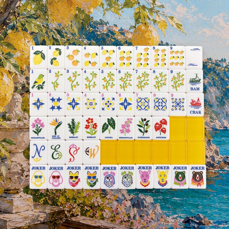 May include: A set of white mahjong tiles arranged in a grid, featuring colorful illustrations of lemons, plants, flowers, geometric patterns, and animals. The tiles include text labels like BAM, CRAK, and JOKER, with some blank yellow tiles included.