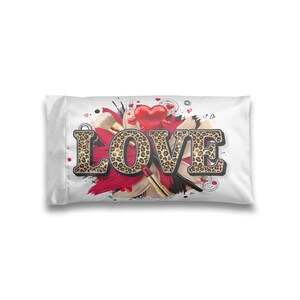 May include: A rectangular white pillowcase featuring the word LOVE in large, leopard-print block letters. The design includes a central red heart, abstract red and black brushstrokes, makeup brushes, and a lipstick tube against a white background.