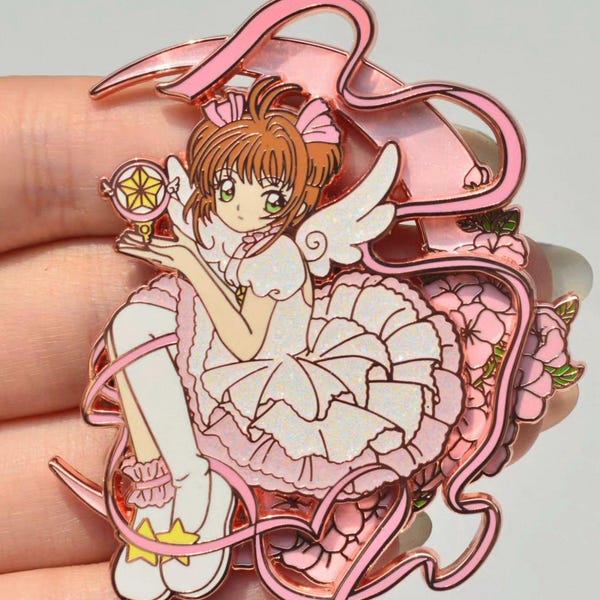 Conjunto de pin e imán inspirado en las Chicas Mágicas: Luna que brilla en la oscuridad, alas con purpurina y acabado en oro rosa.