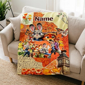 May include: A rectangular fleece blanket featuring a collage of Zootopia characters including Judy Hopps and Nick Wilde. The design incorporates orange and yellow floral patterns, a clock tower, butterflies, and the word Name at the top centre.