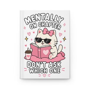 Puede incluir: Un diario de tapa dura blanca con un gato de dibujos animados con gafas de sol y un lazo rosa, leyendo un libro rosa con un corazón. Junto al gato hay una taza de café. El texto dice: MENTALLY ON CHAPTER DON'T ASK WHICH ONE, rodeado de corazones.