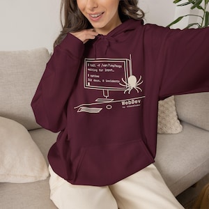 May include: A maroon hooded sweatshirt featuring a white graphic of a computer monitor displaying code with the text $ tail -f /var/log/bugs, waiting for input, $ uptime, 312 days, 0 incidents, WebDev by VibedCoder, and a spider illustration.