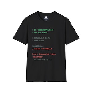 以下が含まれることがあります： 緑、白、赤のテキストでコンピュータコードのグラフィックがプリントされた黒の半袖Tシャツ。プリントには、cd ~/Documents/Life、npm run buildなどのコマンドラインと、Failed to compileと書かれたエラーメッセージが表示されています。