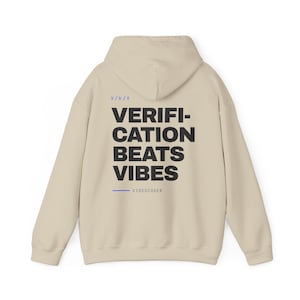 Peut inclure: Un sweat-shirt à capuche beige avec le texte noir VERIFICATION BEATS VIBES imprimé au dos. Au-dessus du texte se trouve l'inscription bleue v/b/v, et sous le texte se trouve une ligne horizontale bleue suivie du petit texte bleu VIBEDCODER.