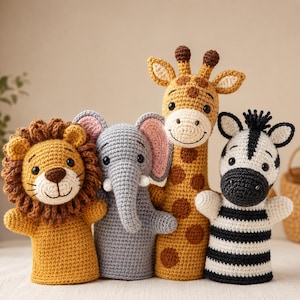 May include: A set of four crochet hand puppets featuring a lion with a brown mane, a gray elephant with pink inner ears, a tall giraffe with brown spots, and a black and white striped zebra, all crafted with detailed yarn stitching and black eyes.