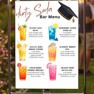 May include: A white Dirty Soda Bar Menu sign featuring a black graduation cap and six illustrated drink recipes: Peachy Keen Grad, Blueberry Lemon Scholar, Banana Boba Bright Future, Rainbow Ribbon Fizz, Strawberry Sunrise Diploma, and Dragon Fruit Dean's List.