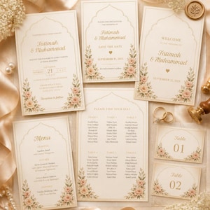 May include: A collection of wedding stationery featuring cream-coloured cards with gold text and floral illustrations. The set includes a wedding invitation, save the date, welcome sign, menu, seating chart, and table numbers, all with arched borders.