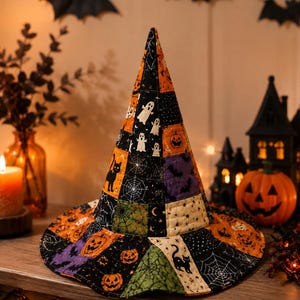 May include: A quilted witch hat featuring a patchwork design of Halloween-themed fabric squares. The pattern includes orange pumpkins, black cats, white ghosts, spider webs, and bats on black, purple, green, and cream-colored fabric backgrounds.