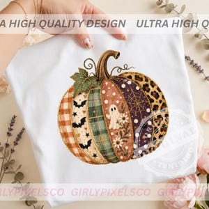 May include: A white t-shirt featuring a large, multi-patterned pumpkin graphic. The pumpkin segments display various designs including orange plaid, black bats, green plaid, a white ghost with flowers, a purple spiderweb, and leopard print.