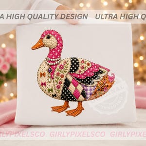 May include: A white fabric surface featuring a detailed illustration of a duck. The duck has a pink head with white polka dots, an orange beak, and a body decorated with floral patterns, black and white polka dots, and small colorful bows.