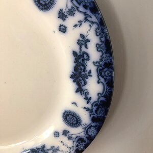 May include: A white ceramic plate with a blue and white floral pattern around the edge.