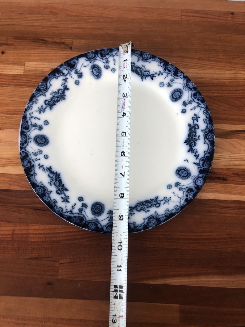May include: A blue and white porcelain dinner plate with a floral design. The plate measures 10 inches in diameter.