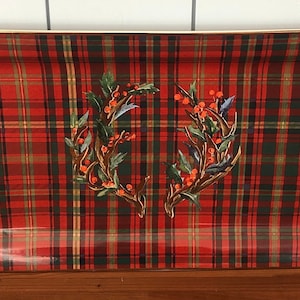 May include: A rectangular serving tray with a red, green, and black plaid pattern. The tray features a decorative design of two wreaths with holly and berries.