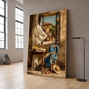 May include: A framed wall art print depicting an open window overlooking a sunlit Mediterranean courtyard. A wooden table holds a bowl of lemons and a glass of wine, while a blue dress hangs on a chair with a straw hat resting on the floor.