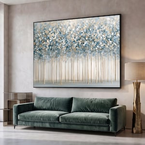Può includere: Una grande opera d'arte murale rettangolare che raffigura una scena forestale astratta con sottili tronchi verticali in oro e bianco. La chioma è composta da tocchi materici di vernice blu, bianca e oro, creando un effetto denso e brillante.