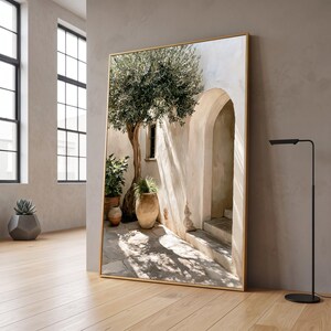 Quadro con cortile mediterraneo, ulivo, vasi di terracotta rustici, arco illuminato dal sole, scena d'esterno vintage