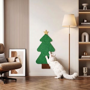 May include: A green felt Christmas tree wall-mounted cat scratcher with a brown rectangular base and a gold star topper. A white cat is shown reaching up to scratch the textured green surface of the tree, which is mounted on a plain wall.