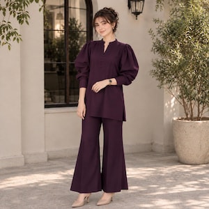 May include: A dark purple two-piece set consisting of a long-sleeved tunic with a mandarin collar, a button-down placket, and voluminous puff sleeves, paired with matching wide-leg trousers that feature a clean, straight-cut silhouette.