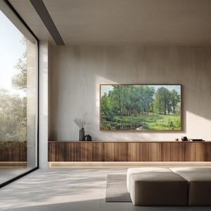 Könnte beinhalten: Ein rechteckiges Landschaftsgemälde mit einem üppig grünen Wald und einem ruhigen Bach, gerahmt in einem dünnen Holzrahmen an einer hellen Wand über einem langen, horizontalen Holzschrank mit vertikalen Lamellen und integrierter Beleuchtung.