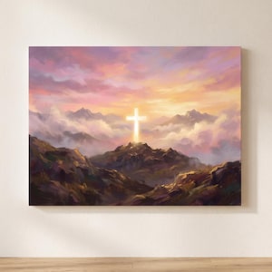 May include: A rectangular wall art print featuring a painted landscape of dark, rugged mountains under a vibrant sunset sky. A glowing, bright white cross stands prominently on the central mountain peak, surrounded by soft, swirling clouds.