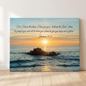 May include: A rectangular wall art print featuring a sunset over the ocean with dark rocks in the water. The text reads: "For I know the plans I have for you," declares the Lord, "plans to prosper you and not to harm you, plans to give you hope and a future." Jeremiah 29:11.