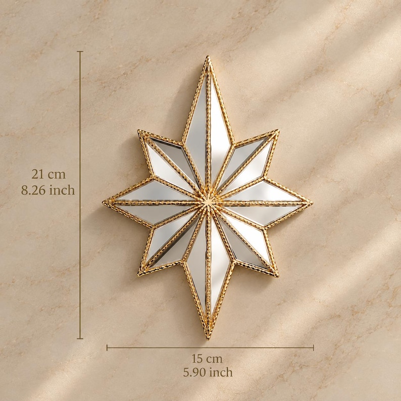 May include: A star-shaped wall mirror with a gold-toned textured frame. The mirror features eight pointed rays and measures 8.26 inches in height by 5.90 inches in width. The reflective surface is divided into triangular segments by the gold frame.
