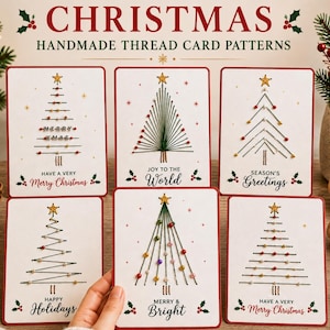May include: Six white rectangular greeting cards featuring handmade thread Christmas tree patterns. Each card displays a stitched tree with a gold star topper, colourful beads, and printed holiday text including Merry Christmas, Joy to the World, and Season's Greetings.
