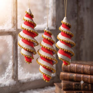 Puede incluir: Tres adornos colgantes en forma de espiral hechos de hilo de ganchillo con rayas alternas rojas y blancas. Cada adorno presenta un borde decorativo de pompones dorados a lo largo de los bordes y está suspendido por un hilo dorado fino.