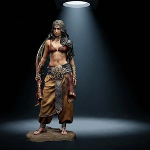 May include: A detailed figurine of a person with long dark hair, wearing a red top, tan trousers, and an ornate belt. The figure features metallic arm cuffs, a headpiece, and sandals, standing on a textured base under a single overhead spotlight.