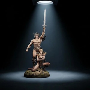 Pode incluir: Uma estatueta detalhada com um guerreiro de pé com capacete de chifres segurando uma espada prateada no alto, enquanto um segundo guerreiro se ajoelha na base. Ambos usam armadura de couro castanho sobre uma base de pedra rochosa.