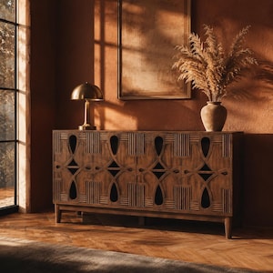 Puede incluir: Un aparador rectangular de madera con cuatro puertas de armario que presentan intrincados recortes geométricos y detalles de listones verticales. La pieza se apoya sobre cuatro patas cónicas y tiene un acabado en tono madera marrón medio con veta visible.