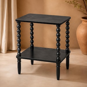 May include: A black side table featuring two square shelves with a visible wood grain texture. The table is supported by four vertical legs, each composed of a series of stacked, rounded wooden spheres that create a distinct beaded appearance.