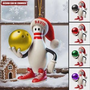 May include: A white bowling pin ornament wearing a red Santa hat with the name DAVID printed on the brim. The pin has black arms, white gloves, and red high-top sneakers, holding a large gold bowling ball. Additional variations show different colored balls.