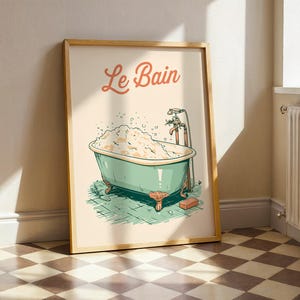 May include: A framed wall art print featuring a vintage-style illustration of a clawfoot bathtub filled with bubbles. The text Le Bain is written in a cursive orange font above the tub, which is colored in light green with orange feet.