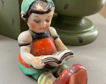 Bambina in porcellana giapponese che legge